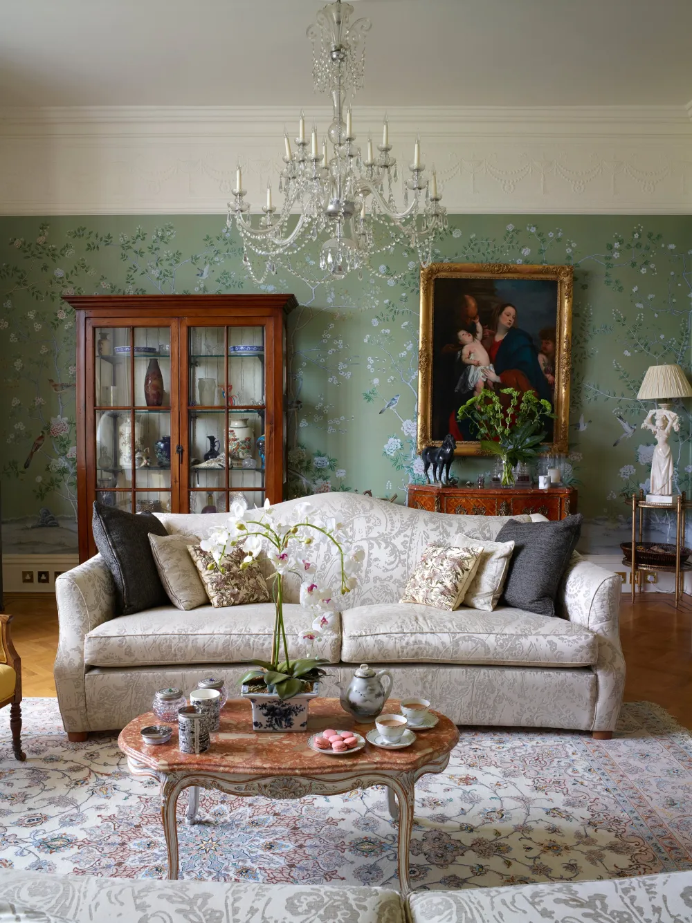 Salotto con divano, tavolino e carta da parati chinoiserie verde
